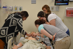 Four patients checking vitals on  a manikin simulator